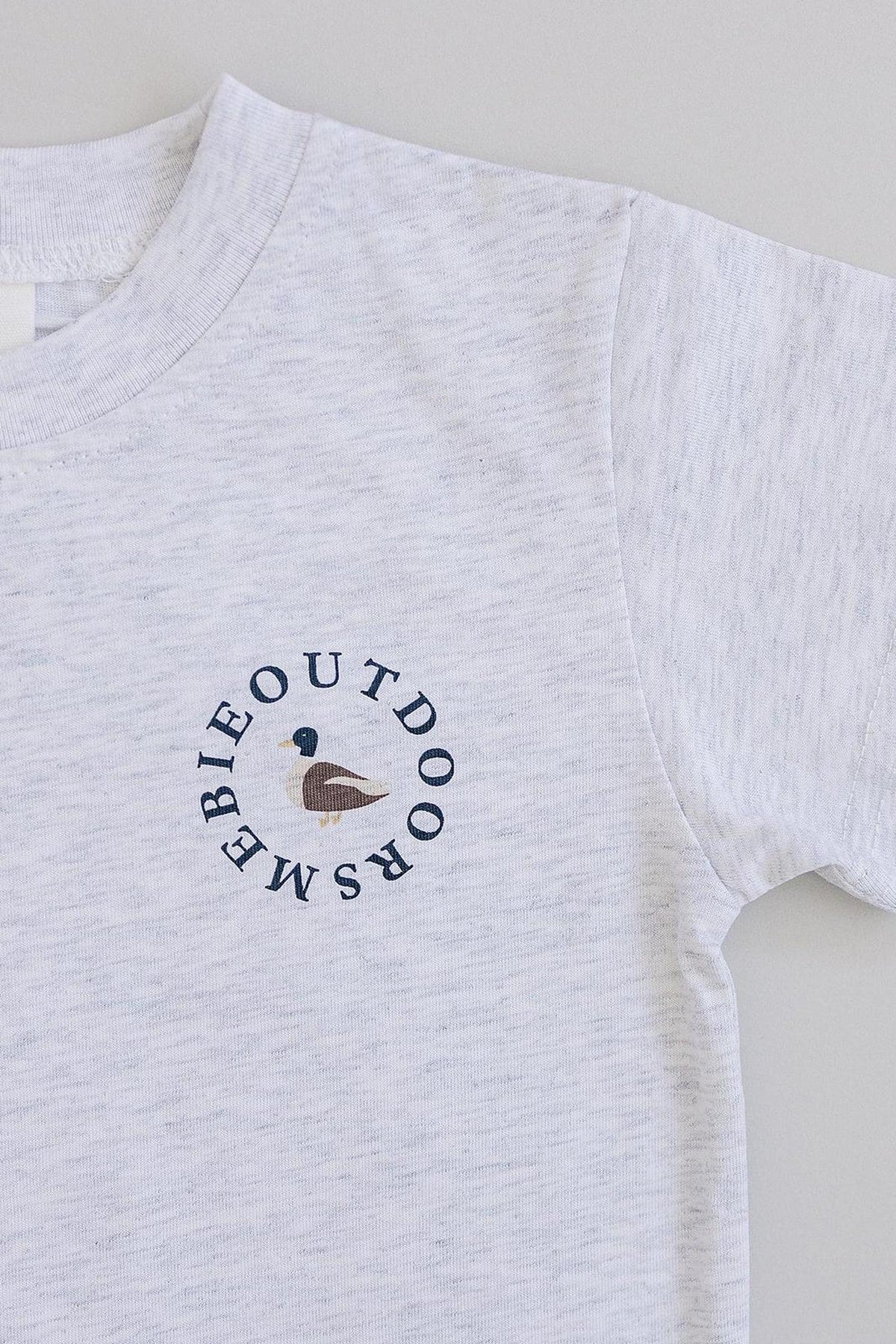 White cotton T-shirt with a duck graphic and Mebie Outdoors text in a circular design.