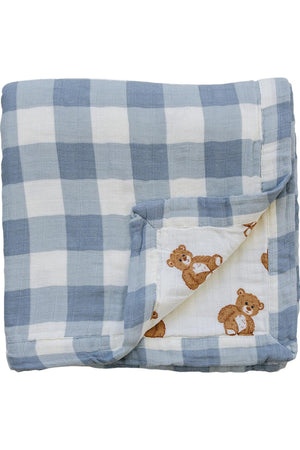 Dusty blue gingham muslin crib quilt featuring a playful teddy bear print on one side. Made from 100% organic cotton, this quilt is soft and perfect for infants.