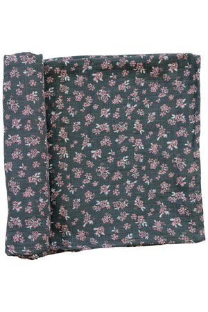 Dark green muslin swaddle blanket with pink floral pattern, made from 100% cotton, displayed folded on a white background.