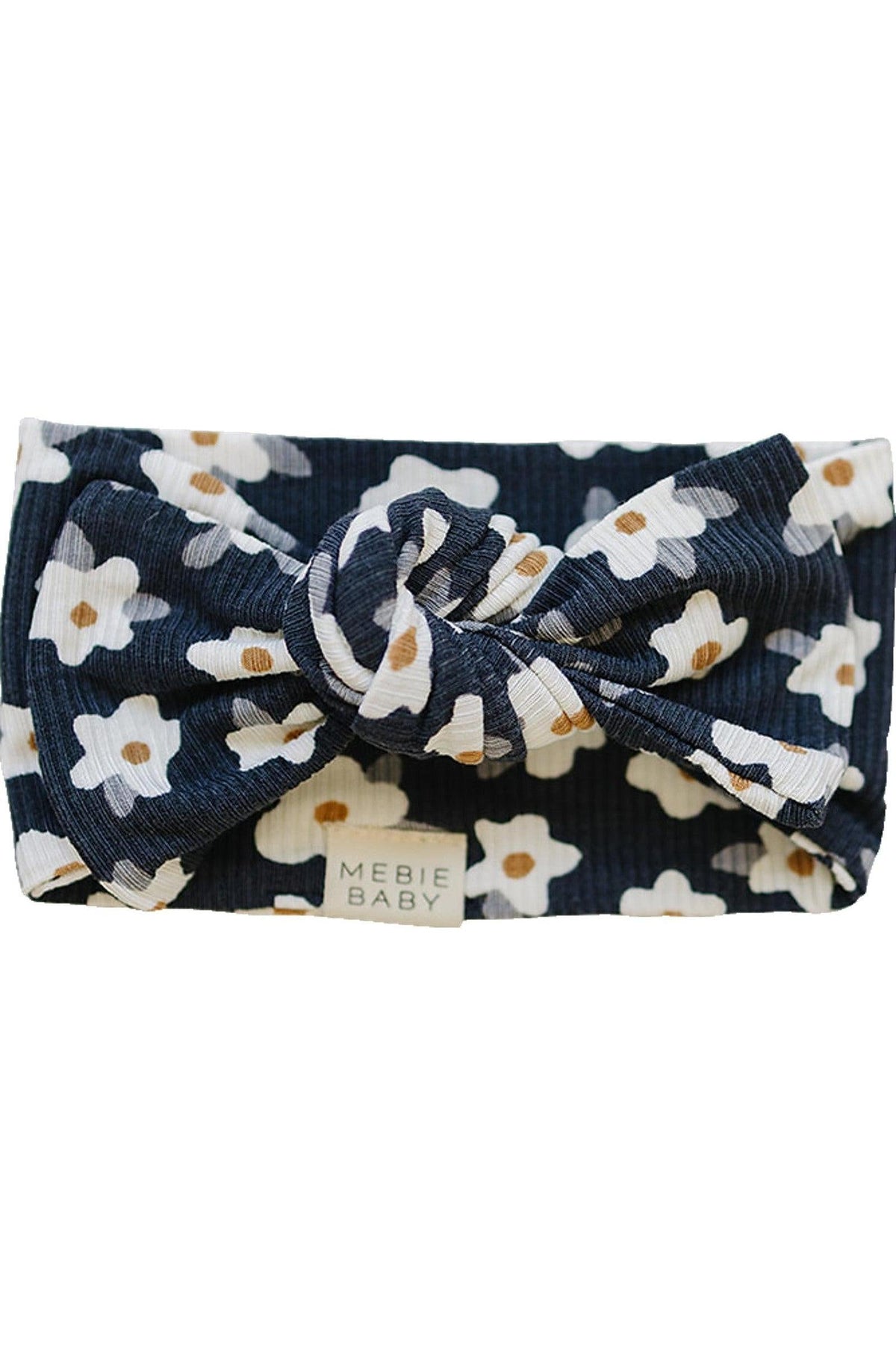 Navy ribbed baby head wrap with white daisy pattern, featuring a central knot. Mebie Baby label attached.