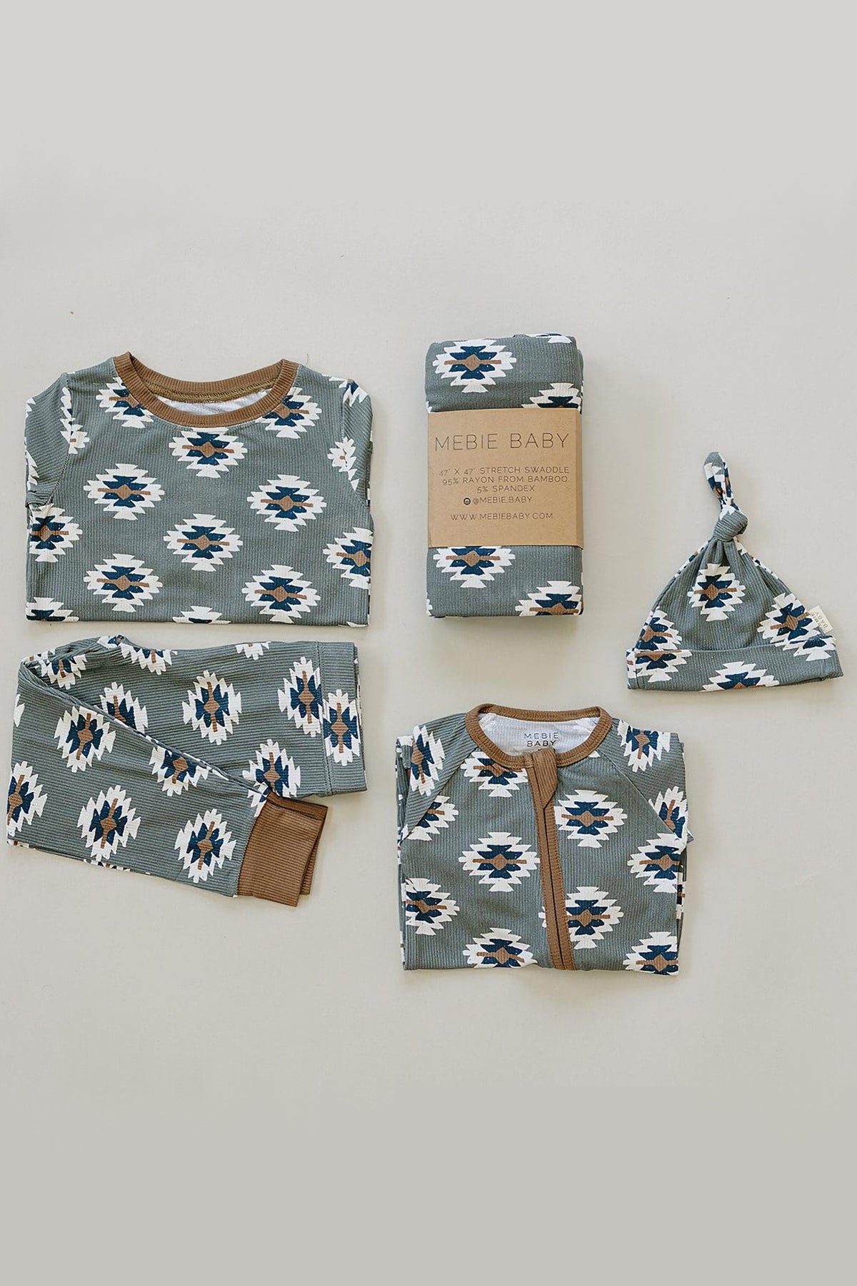 Green Aztec-patterned pajama set with brown accents, matching hat, and swaddle, made from eco-friendly bamboo fabric.