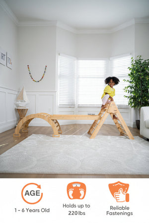 A child plays on a wooden Pikler triangle and slide set in a bright room with white walls and large windows. The natural wood finish highlights its sustainable, eco-friendly design.