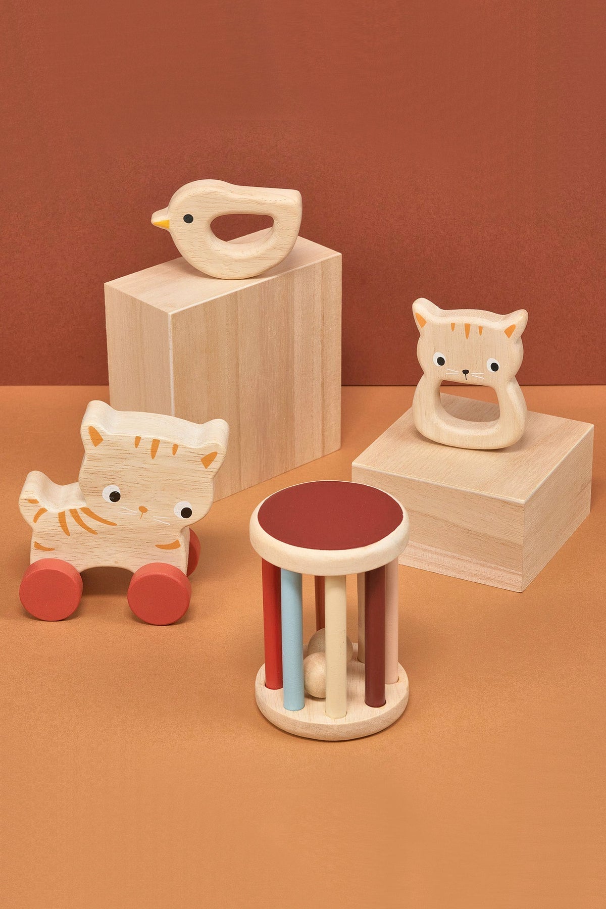 Set of wooden toys including a bird, cat, and ring on a brown background