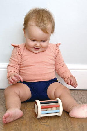 Baby sitting on a wooden floor with a colorful toy