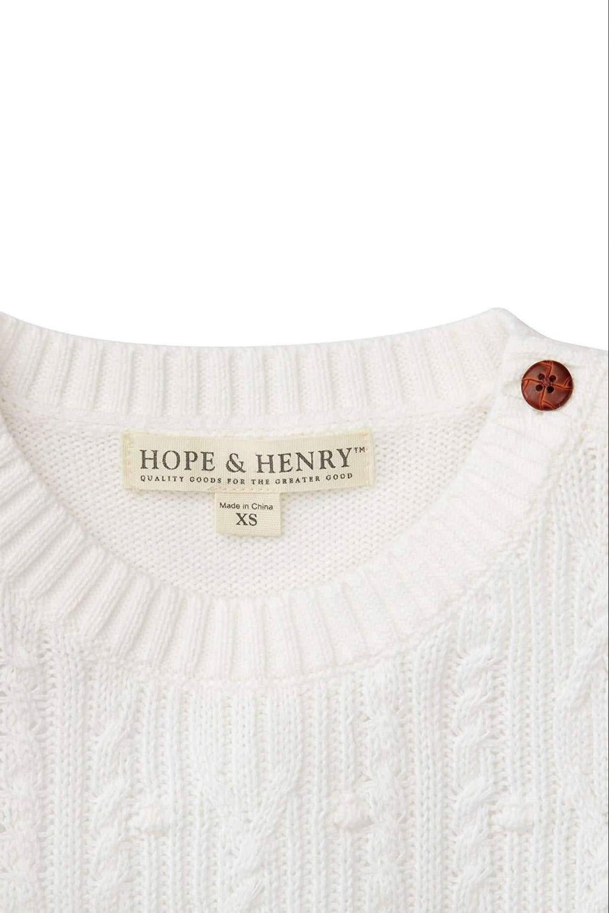 Close-up of a soft white cable knit sweater featuring a round neckline, a brown button, and a Hope & Henry.