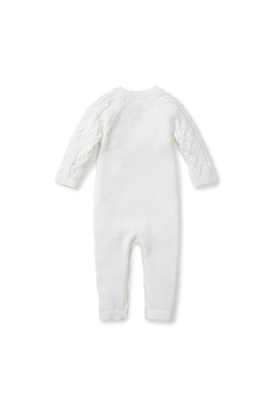 A soft white cable knit sweater romper for babies, featuring long sleeves and a cozy design. Made from 100% organic cotton, it combines comfort with sustainable materials for eco-conscious parenting.