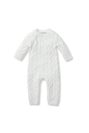 A soft white cable knit romper for babies features long sleeves and button openings at the shoulder. Made from 100% organic cotton, it combines comfort with eco-friendly design.