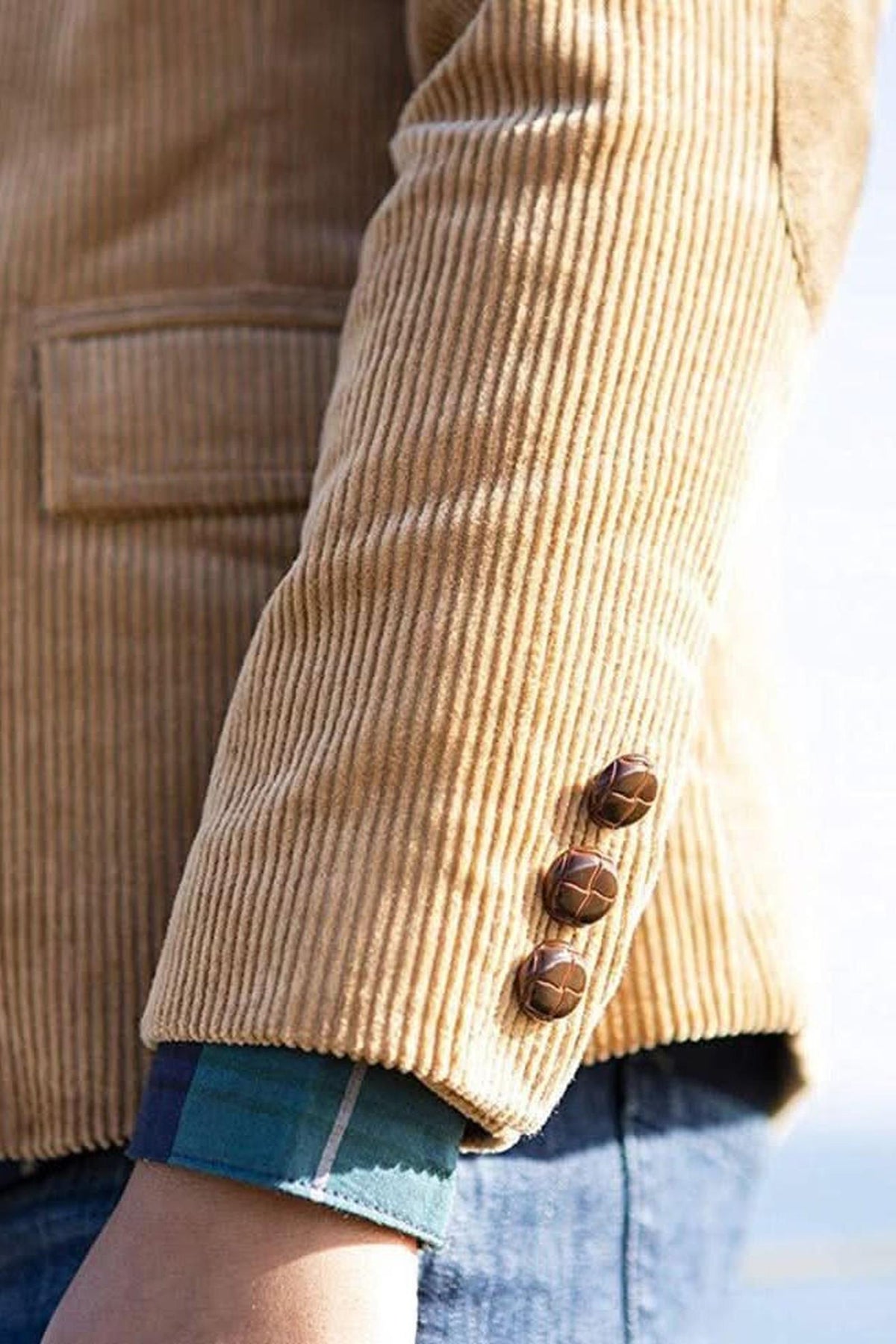 Close-up of a medium brown corduroy blazer for boys, featuring button details and a textured fabric. The blazer showcases a stylish design suitable for both casual and dressy occasions.
