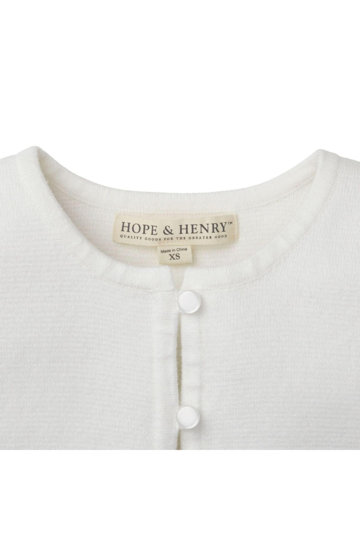 Close-up of a white cardigan by Hope & Henry featuring a round neckline and pearlized button closure.