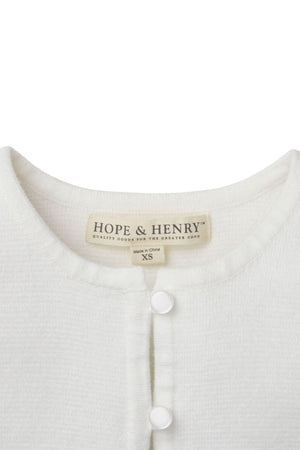 Close-up of a white Hope & Henry organic cotton cardigan featuring a button closure and soft texture, labeled XS.