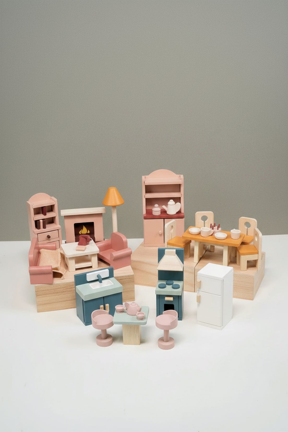 Wooden dollhouse furniture set with kitchen, dining, and living room pieces in pastel colors on a white background.