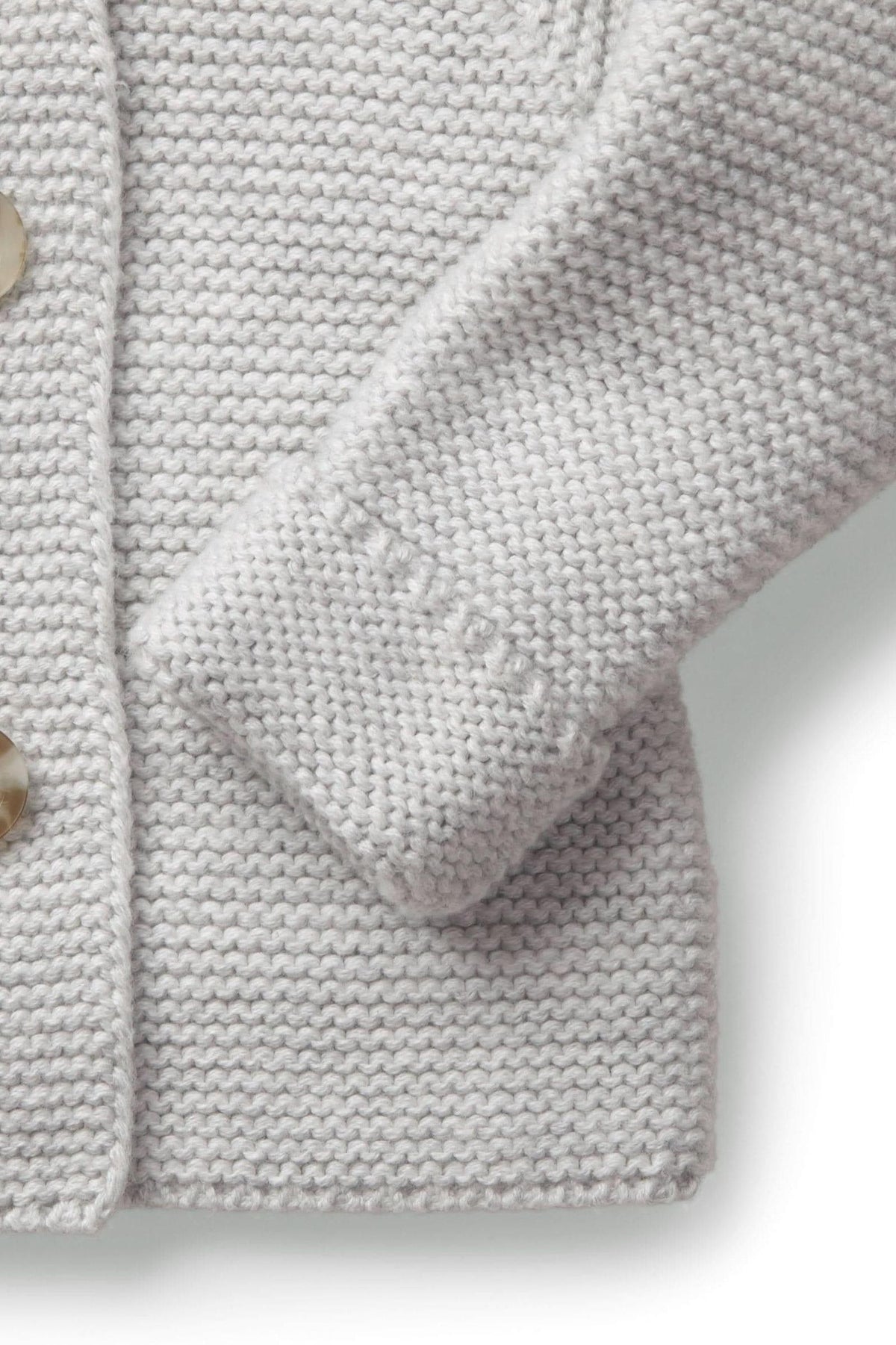 Light gray knitted sweater showcasing a soft texture, featuring a rounded collar and a button closure. Perfect for babies.