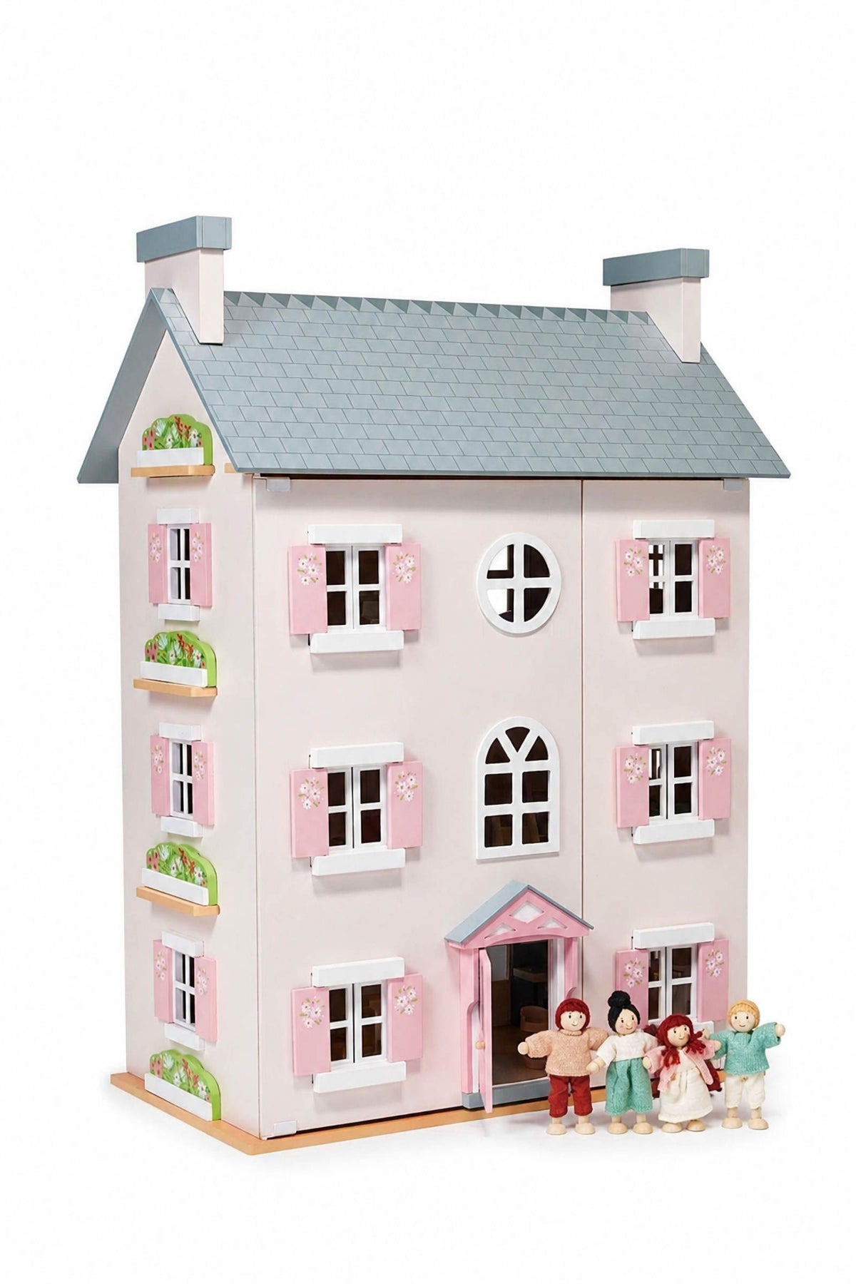 A charming wooden dollhouse with a pink and white exterior features flower-adorned shutters and a blue roof. The set includes five colorful doll figures, perfect for imaginative play.