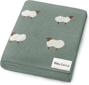 A soft, green swaddle blanket featuring playful sheep designs, crafted from OEKO-Tex certified Pima cotton by Bleu-La-La. Ideal for newborns, it offers a gentle and breathable embrace.