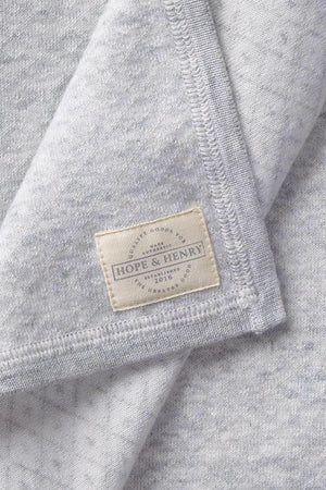 Close-up of a gray organic cotton fabric featuring a subtle diamond pattern, with a visible label reading Hope & Henry. The soft material suggests comfort for babies and toddlers.