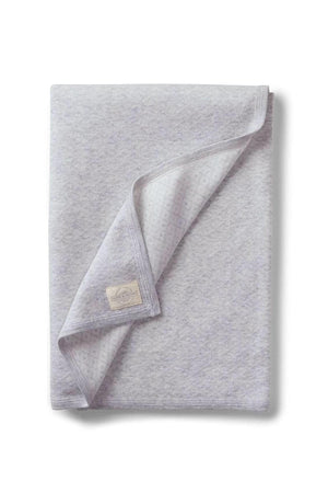 A soft gray blanket made from organic cotton features a subtle jacquard pattern. Ideal for babies, it’s perfect for strollers and outings, showcasing sustainable, family-friendly design.