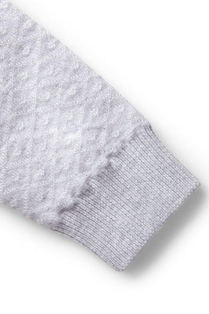 Close-up of a light gray sweater romper sleeve featuring a textured diamond pattern and ribbed cuff, made from organic cotton.