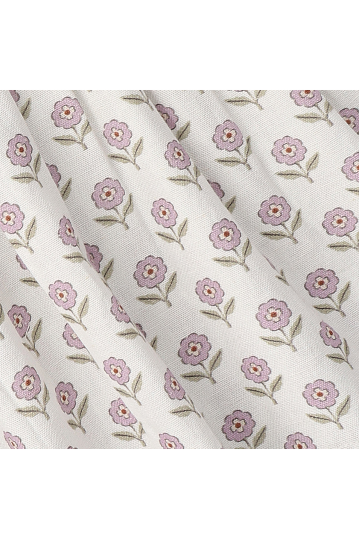 Delicate lavender flowers with green leaves are printed on a soft, cream-colored fabric. This organic cotton material features a charming floral pattern, perfect for childrens clothing and sustainable fashion.