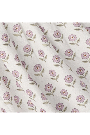 Delicate lavender flowers with green leaves are printed on a soft, cream-colored fabric. This organic cotton material features a charming floral pattern, perfect for childrens clothing and sustainable fashion.