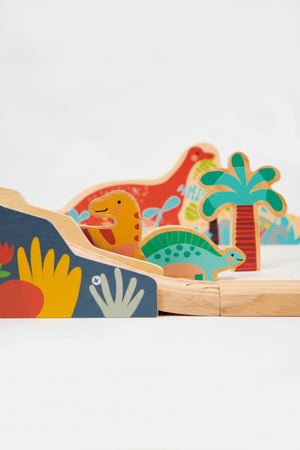 Colorful wooden dinosaurs and trees on a wooden railway track, featuring playful designs and vibrant colors.