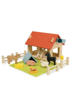 A wooden farm playset features a red-roofed barn, colorful animal figures, and a grassy area with fences. This eco-friendly toy encourages imaginative play for young children.