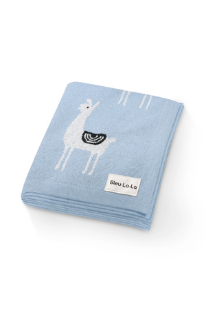 Light blue knit blanket with white llama design and Bleu La La label, showcasing cozy, sustainable fabric.