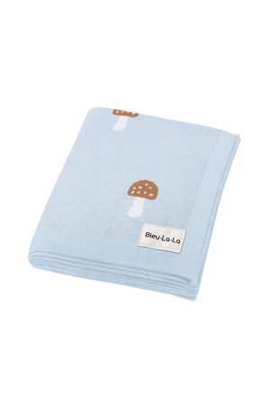Light blue blanket with brown mushroom patterns, folded neatly, featuring a Bleu La La label.