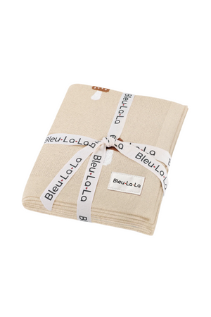 Folded beige knit blanket with mushroom design, tied with a branded Bleu La La ribbon, on a white background.
