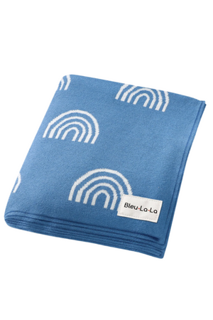 Blue knit blanket with white rainbow pattern, featuring a Bleu-La-La label. Soft, cozy texture ideal for babies.