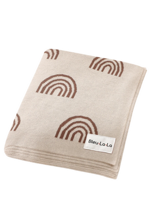 Folded beige blanket with brown rainbow patterns and a Bleu-La-La label, made from soft cotton material.