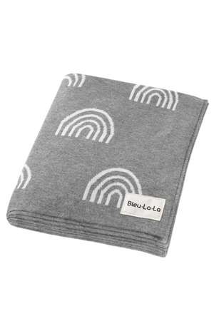 Gray knit blanket with white rainbow patterns, featuring a Bleu-La-La label, made from soft, sustainable cotton.