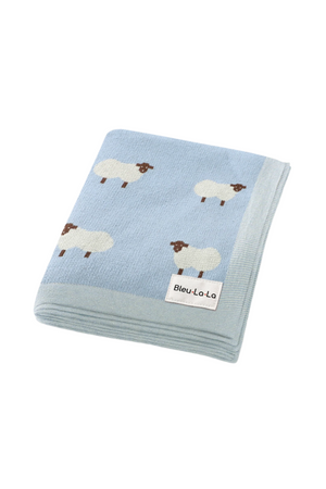 Light blue knit blanket with sheep patterns, made of soft cotton, featuring a Bleu La La label.
