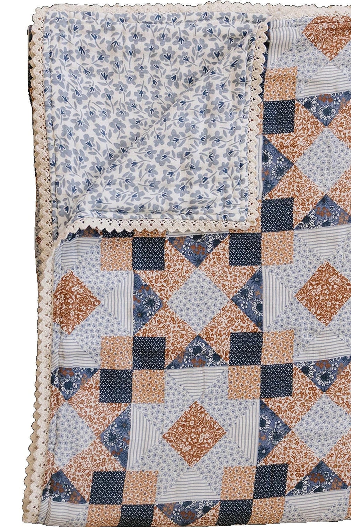 A twin muslin quilt featuring a patchwork design in blue, orange, and cream, with a delicate lace edge.