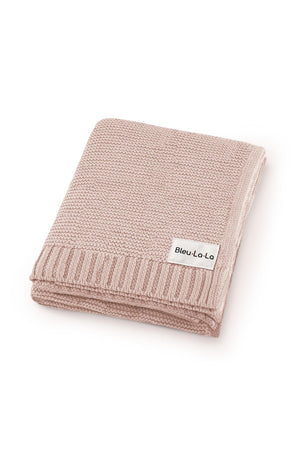 Soft pink knit baby blanket with ribbed edges and a Bleu La La label, made from organic cotton.