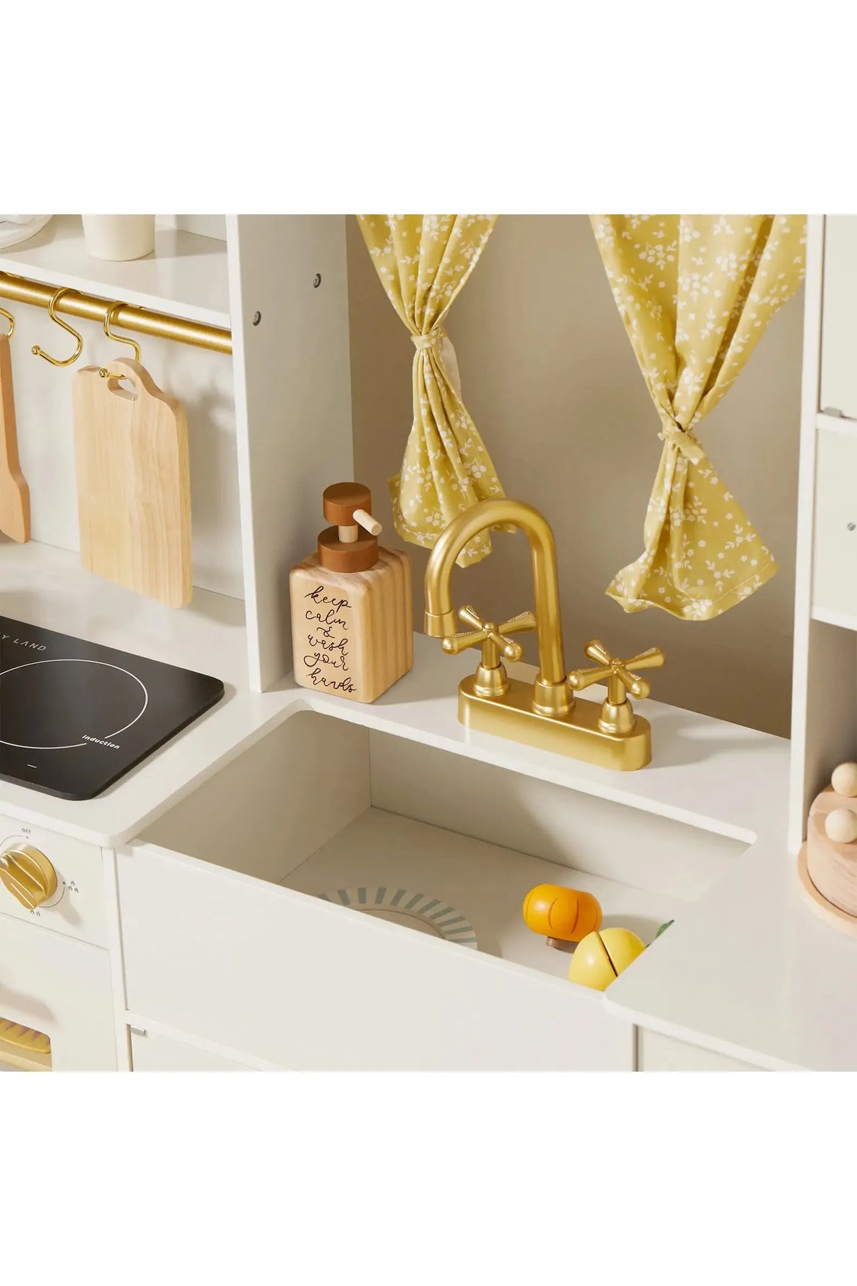 The image features a cream-colored wooden play kitchen with a gold faucet, decorative curtains, and various wooden accessories. It is designed for imaginative play, suitable for toddlers and kids.