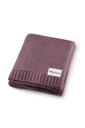 A folded mauve knit blanket with a label reading Bleu-La-La on a white background.