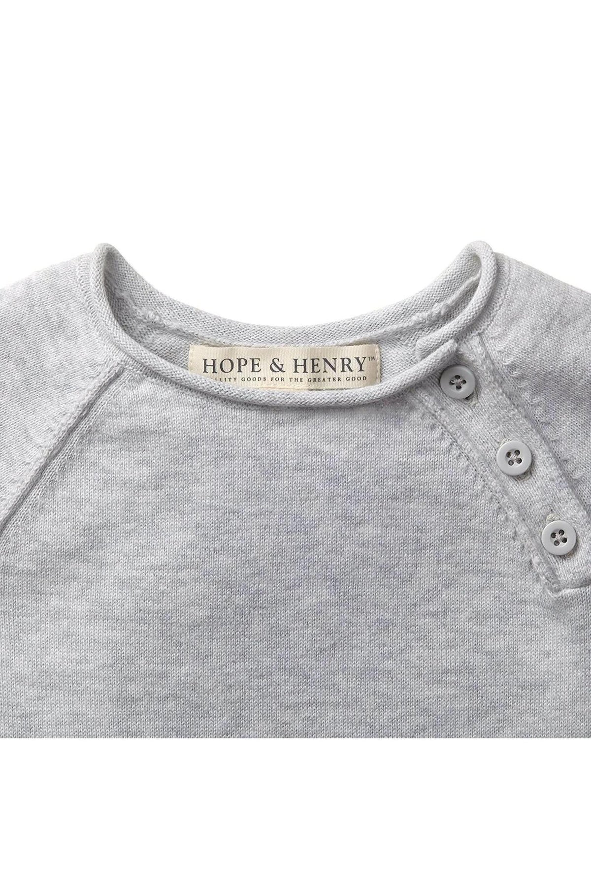 Close-up of a light heather grey organic cotton baby romper by Hope & Henry, featuring a soft neckline, rolled edges, and decorative buttons at the shoulder.