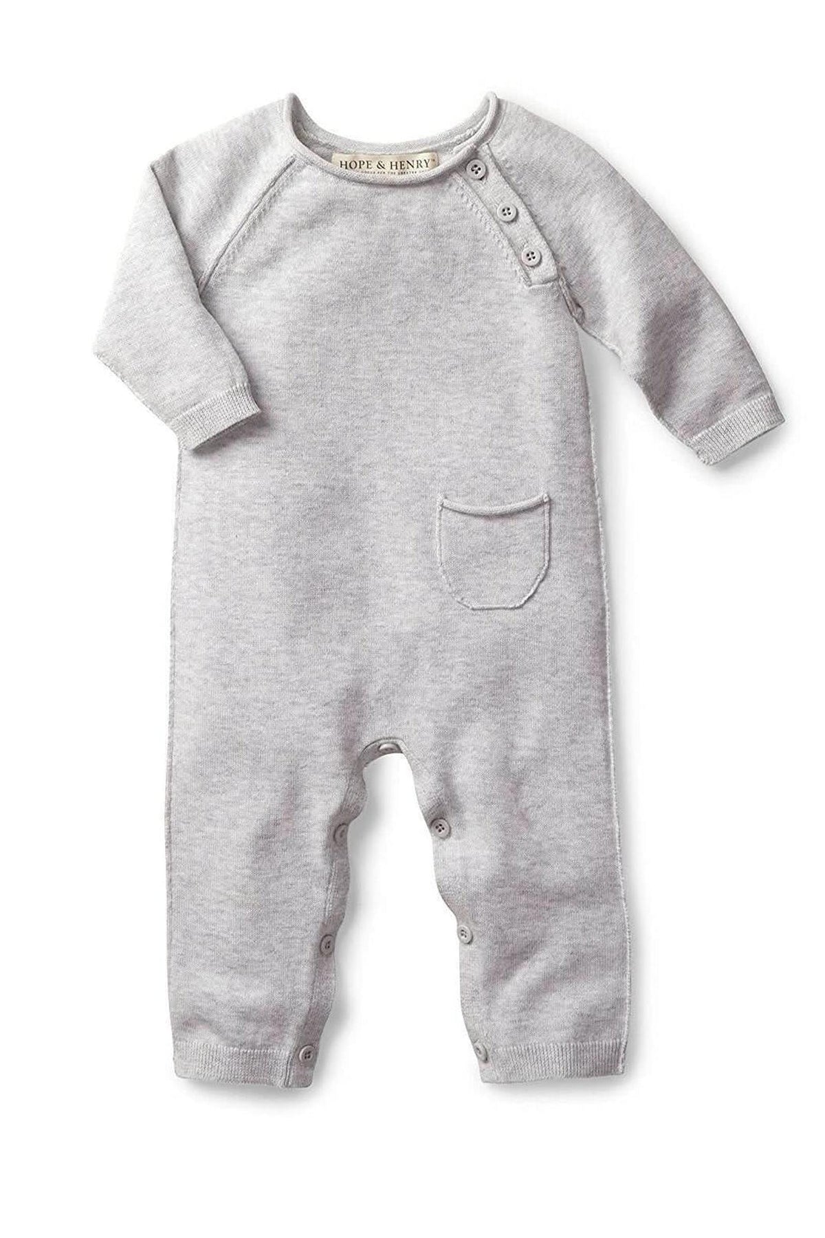 A light gray organic cotton romper features long sleeves, a small chest pocket, and snap closures at the bottom.
