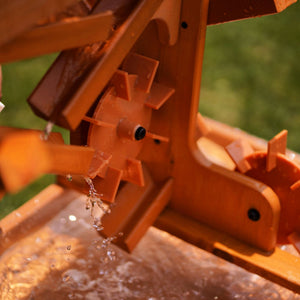 Close-up of a wooden water table featuring a water wheel, with clear water flowing over the wheel. The natural wood finish highlights its eco-friendly design, perfect for toddler sensory play.