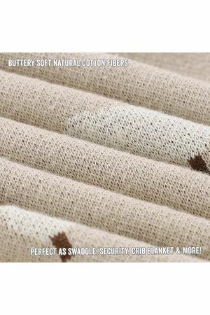 Close-up of a beige knit fabric with a small brown sheep pattern, showcasing its soft texture and fine weaving.