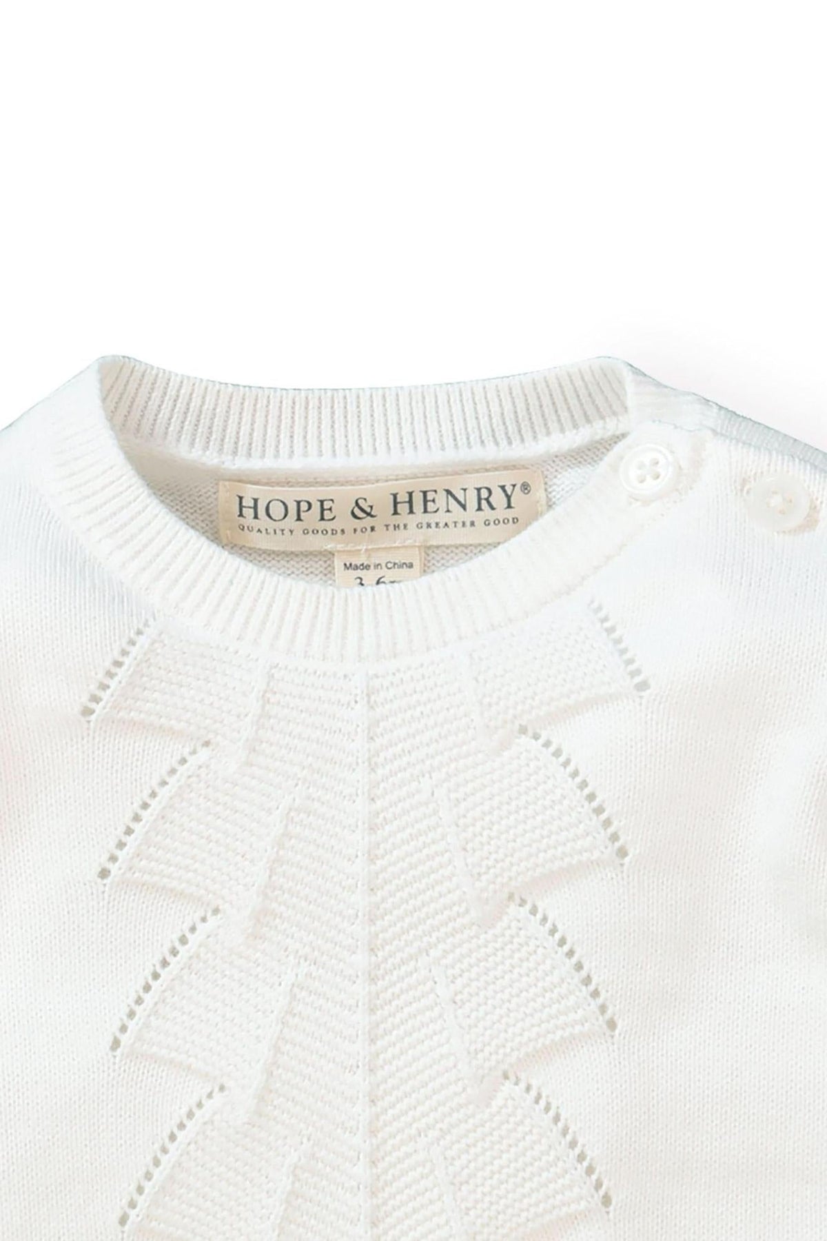 Close-up of a soft white organic cotton sweater gown from Hope & Henry, featuring delicate pointelle detailing and shoulder buttons.