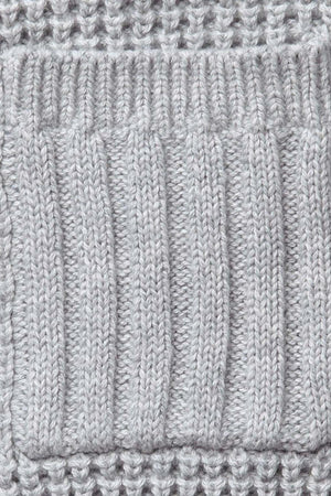 Close-up of a textured gray knit fabric featuring ribbed and waffle stitch patterns, showcasing its soft organic cotton composition.