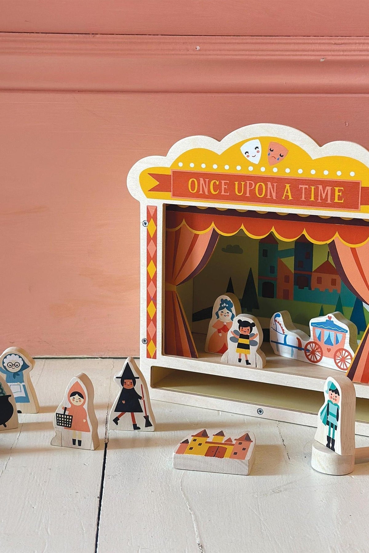 Wooden tabletop theatre with colorful characters and a Once Upon a Time sign, set on a white surface.